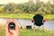 Round compass in hand against background of summer landscape on river fishing as symbol of tourism with compass