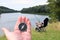 Round compass in hand against summer landscape on river fishing