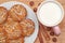 Round cookies with sunflower and sesame seeds, milk in pink mug, top view. Valuable breakfeast.