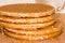 Round cookies or wafers with a layer of caramel lies on a rough