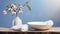 a round dish adorned with a white towel, cotton pads, a wooden brush, and a glass vase with a tree branch, an inviting