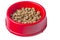 Round dry food in a red bowl isolated on white. Balanced nutrition for pets