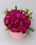 Round flower composition of pink flowers in cylindrical gift box.