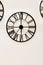 Round forged vintage clock on wall. Antique clock on background of light wall. Abstract background