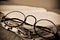 Round-framed eyeglasses and old book, in sepia toning