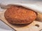 Round freshly baked homemade wholegrain bread loaf lies on a wooden kitchen board