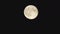 Round full moon with relief elements quickly rises in the black sky