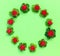 Round garland  from  leaves and berries, on green paper background, flat lay, top view. The concept of summer, spring, Mother`s