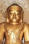 Round golden Buddha face in temple in Myanmar