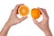 Round halfs of rip orange fruit in hands of an elderly cook. Is