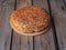 Round homemade bread with flaxseeds and sesame on a rustic table