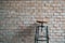 Round industrial stools with brick wall background.