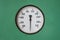 Round industrial thermometer on a machine green background