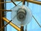 Round lantern on a pedestrian bridge with a transparent roof and blue sky, closeup and reflections