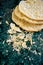 Round layered napoleon cakes with custard and sprinkled crumbs on a green marble table, top view. The process of cooking, recipe