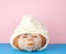 Round orange pumpkin wrapped in a white terry towel, face mask on the surface. concept of relaxation