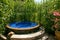 Round outdoor jacuzzi among tall thickets and grass