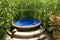 Round outdoor jacuzzi among tall thickets and grass