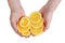 Round pieces of rip orange fruit in hands of an elderly cook