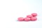 Round pink tablets pill on white background. Vitamins and minerals plus folic acid vitamin E and zinc in drug bottle