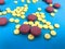 Round pink and yellow pills volumetric structure on a blue matte background. health medications. Herbal medicines poured