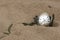 Round pocket watch on a chain in the sand