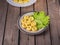 Round potatoe njeki on fresh lettuce leaves on a striped bright ceramic plate on a plank table