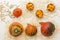 Round pumpkins on a straw and seeds on a white background. Sliced pieces in wooden bowls. Top view