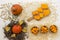 Round pumpkins on a straw and seeds on a white background. Sliced pieces in wooden bowls. Top view