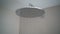 Round rain shower showerhead with open running water closeup in bathroom