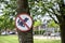 Round red and white no dogs poop zone sign in front of children playground in a neighbourhood