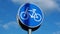 Round road sign depicting white bicycle on blue background, meaning mandatory bike path for cyclists against blue sky