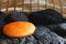 Round shape bright orange cushion on black shinny blanket