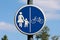 Round shaped blue and white road sign for pedestrian and bicycle zone mounted on metal pole