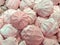 Round-shaped marshmallow candies lying in pile. Sweets of white and pink color