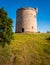 Round shaped, small, stone built, castle on plot of countryside land.