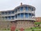 Round-shaped wooden house in the capital of Georgia, Tbilisi, in the Caucasian style with a masonry base and a balcony terrace