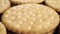 Round shortbread biscuits with dotted pattern stacked in rows.
