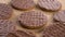 Round shortbread cookies coated with chocolate on a rustic burlap