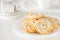 Round shortbread cookies rose form with icing on plate. White ba