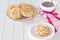 Round shortbread cookies roses form. Cup of hot chocolate. Vintage white plate and napkin. White background wooden