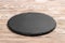 Round slate stand board a wooden background. space for text