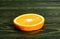 Round slice bright juicy ripe beautiful orange on a coarse dark wooden background from boards