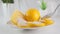 A round slice of yellow lemon is sprinkled with sugar on white saucer closeup. Slow motion