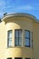 Round spire or turrent on side of building with panoramic windows on beige structure in the city midday sun