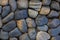 Round stone paving. Natural stone masonry top view. Seaside pebble photo texture. Stone wall surface