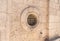 The round stone window with iron bars in the wall of the Deir Al-Mukhraqa Carmelite Monastery in northern Israel