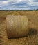 Round straw bales in harvested fields.