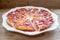 Round strawberry pie with fresh strawberries cut on white plate dish on wooden table background