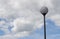 Round street lamp against a cloudy sky